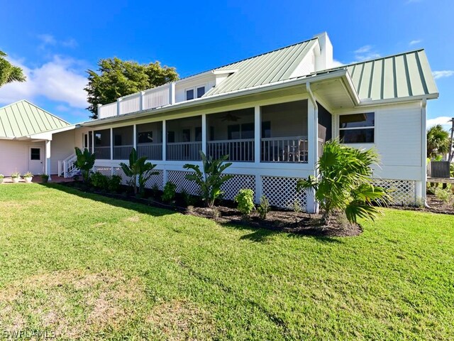 rear view of property featuring a lawn