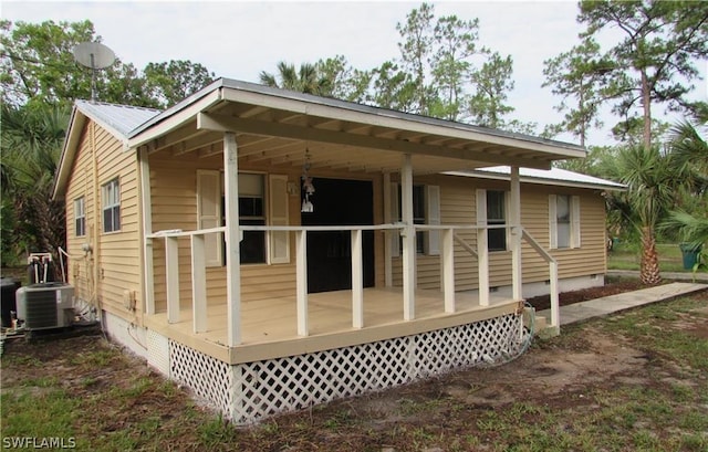 440 14th Ave NE, Naples, FL 34120 - view of side of home with central AC unit, crawl space, and covered porch
