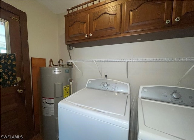 washroom with washer and dryer, cabinets, and water heater