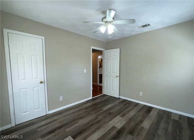 unfurnished bedroom featuring dark wood-type flooring and ceiling fan