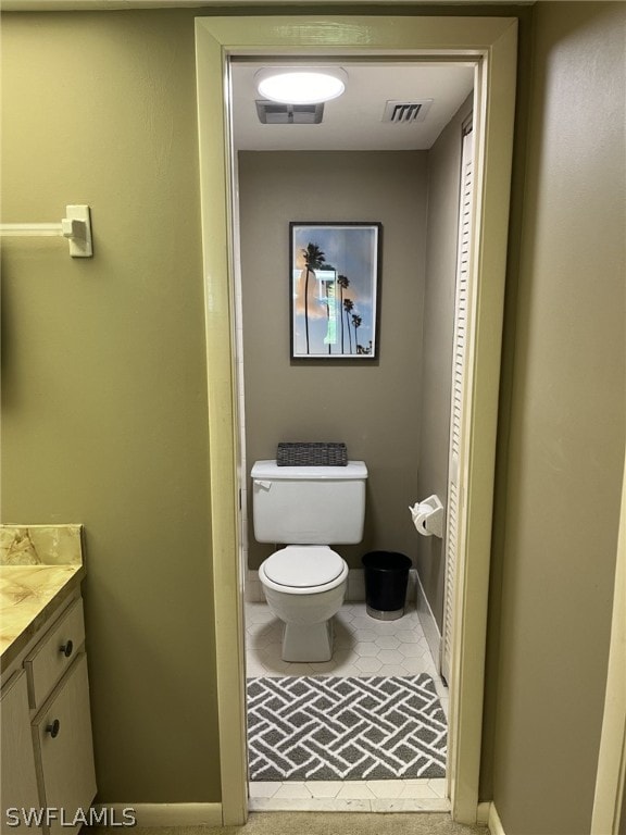 bathroom with vanity, toilet, and tile patterned flooring