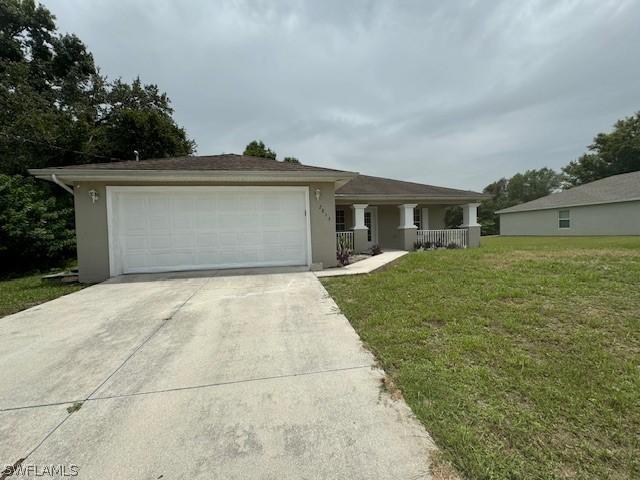 2813 52nd St W, Lehigh Acres, FL 33971 - view of front facade featuring driveway, a front yard, covered porch, stucco siding, and a garage