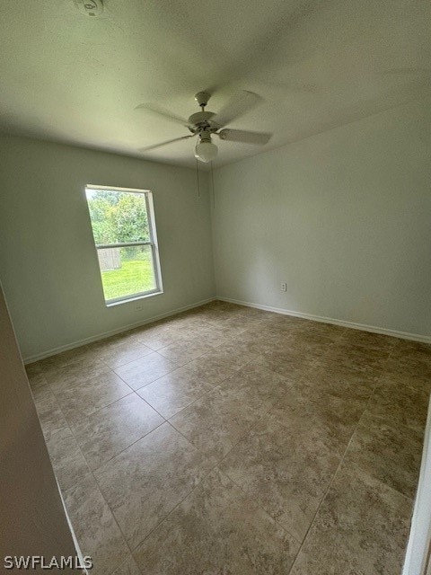 spare room with tile patterned floors and ceiling fan