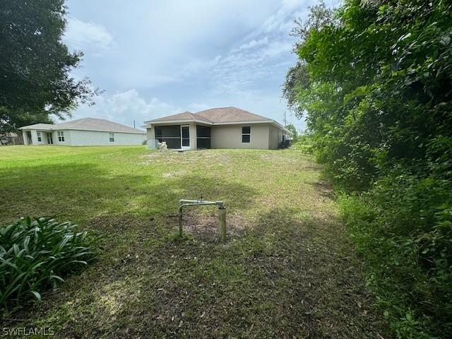 2813 52nd St W, Lehigh Acres, FL 33971 - view of green lawn with a sunroom