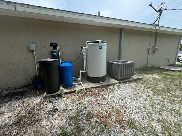 2813 52nd St W, Lehigh Acres, FL 33971 - exterior view of stucco siding, a water softener system, and a water pressure tank