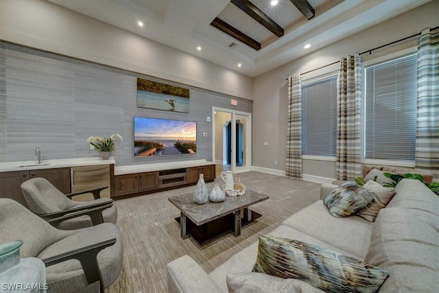 living room featuring a high ceiling, wet bar, and beamed ceiling