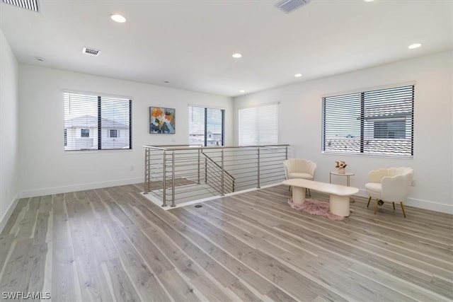 living area with light hardwood / wood-style flooring and a healthy amount of sunlight