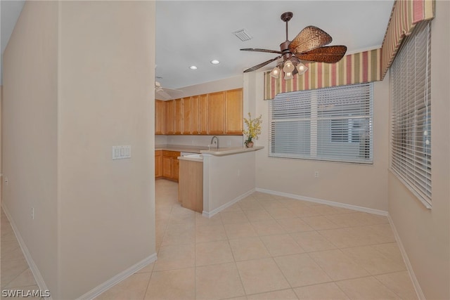 kitchen with ceiling fan, light brown cabinetry, and light tile patterned floors