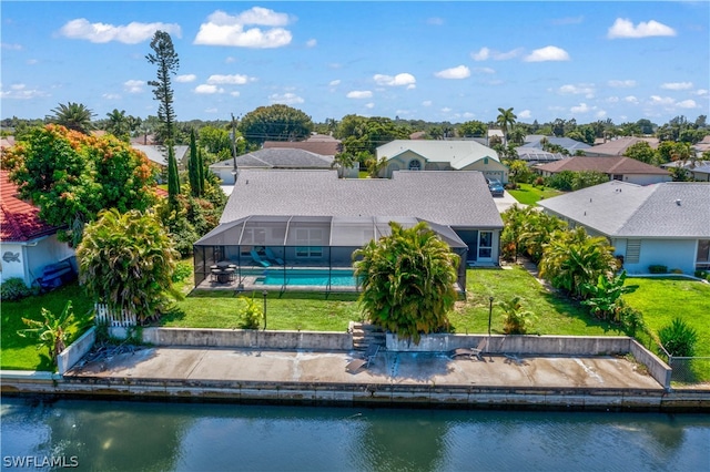 back of house featuring a lanai, a water view, a swimming pool, and a lawn