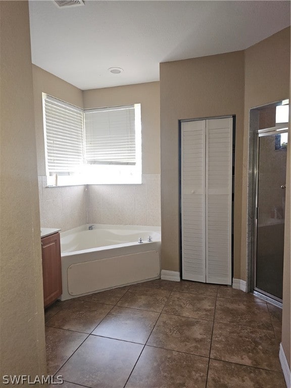 bathroom featuring independent shower and bath, vanity, and tile patterned flooring