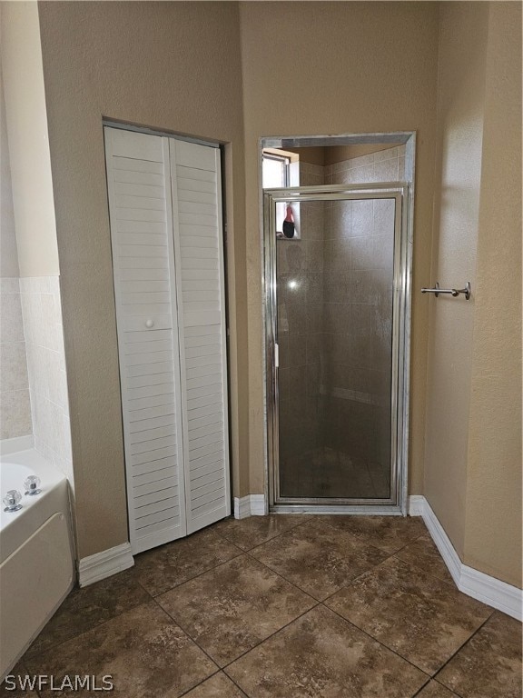 bathroom featuring tile patterned floors and separate shower and tub