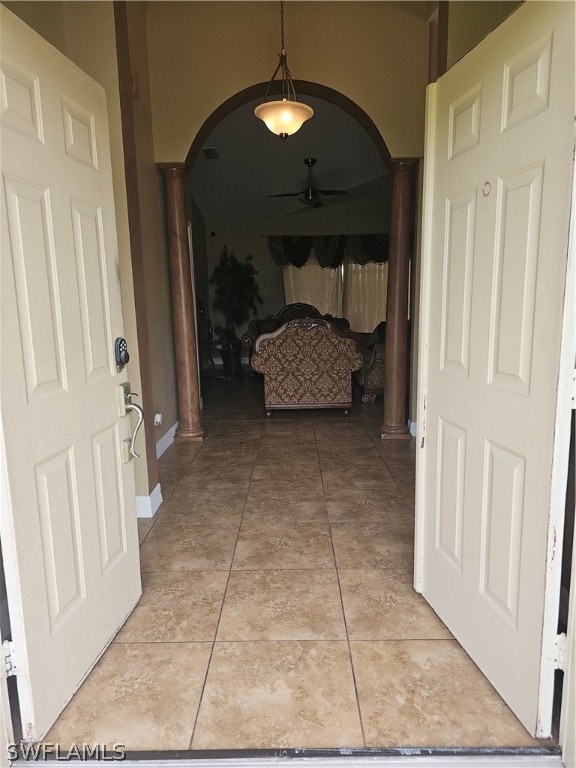 hall with decorative columns and tile patterned floors