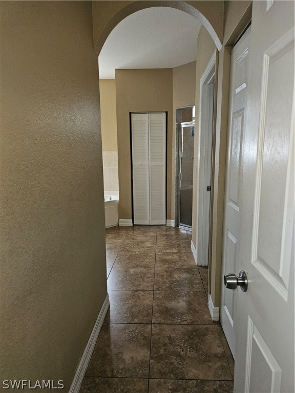 hallway featuring dark tile patterned flooring