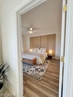 bedroom with hardwood / wood-style flooring, ceiling fan, and crown molding