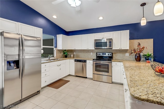 kitchen featuring light tile patterned flooring, white cabinetry, hanging light fixtures, appliances with stainless steel finishes, and backsplash