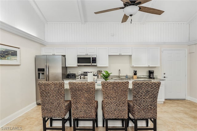 kitchen with sink, appliances with stainless steel finishes, an island with sink, ceiling fan, and white cabinets