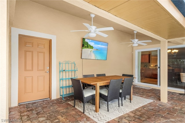 dining area featuring vaulted ceiling with beams and ceiling fan with notable chandelier