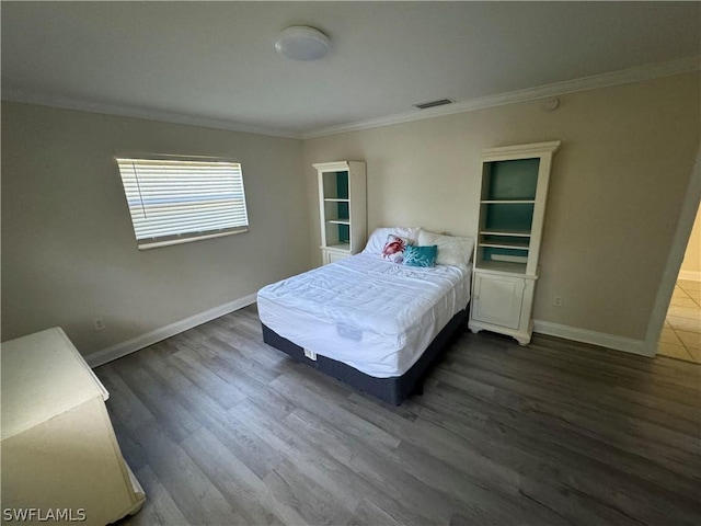 bedroom with ornamental molding and dark hardwood / wood-style flooring