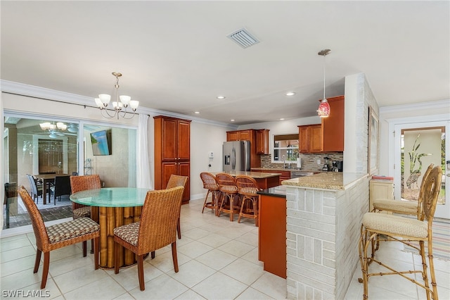 tiled dining area featuring ornamental molding, sink, and a notable chandelier