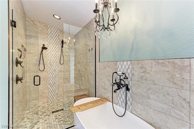 bathroom featuring a textured ceiling, tile walls, and plus walk in shower