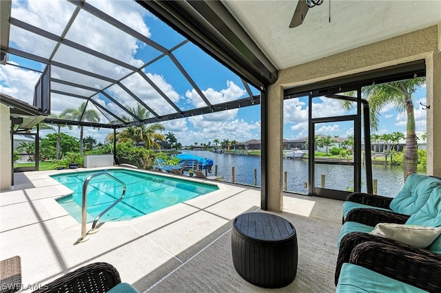 view of pool featuring a patio, a water view, a lanai, and ceiling fan