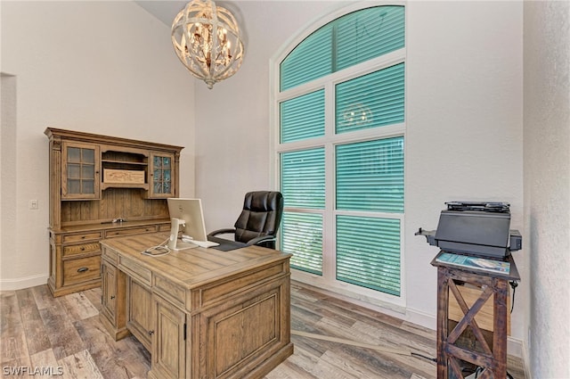 home office featuring a chandelier and light hardwood / wood-style floors