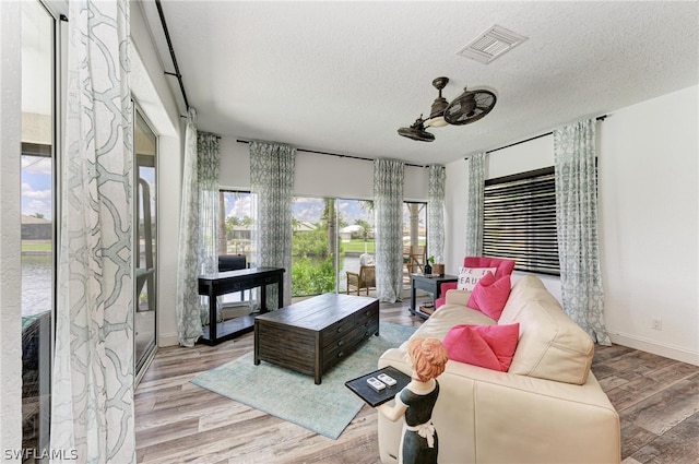 living room featuring a textured ceiling and light hardwood / wood-style flooring