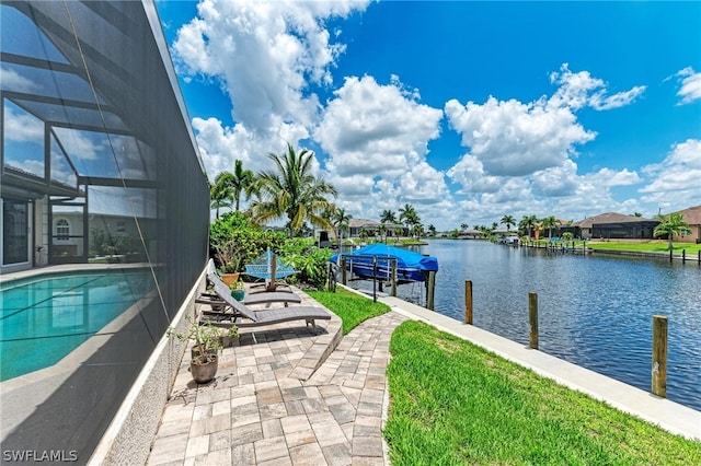 view of pool with glass enclosure, a boat dock, and a water view