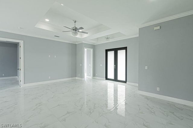 empty room with ornamental molding, a tray ceiling, ceiling fan, and french doors