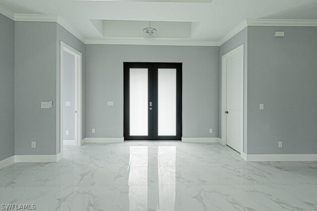 empty room with crown molding, french doors, and a raised ceiling