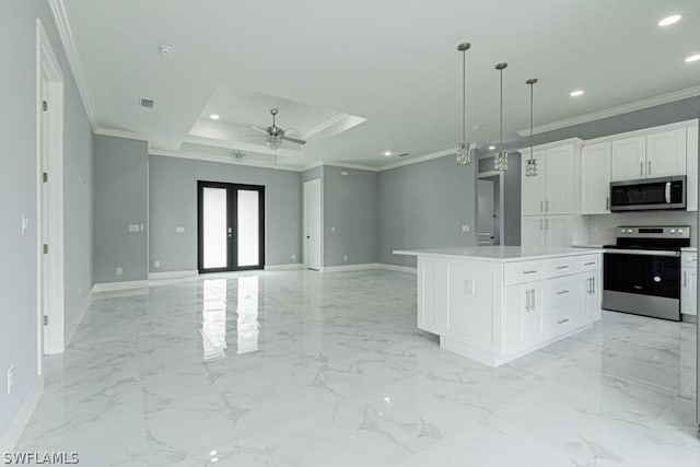 kitchen with a kitchen island, a raised ceiling, white cabinets, ceiling fan, and stainless steel appliances