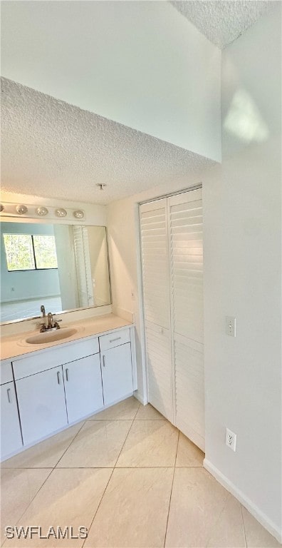 bathroom featuring tile patterned flooring, a textured ceiling, and vanity