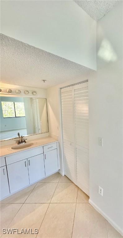 bathroom with vanity, tile patterned flooring, and a textured ceiling