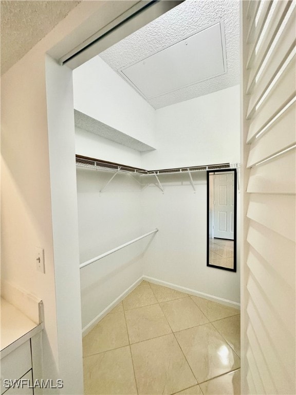 walk in closet with light tile patterned floors