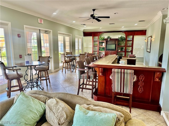 tiled living room with ceiling fan and ornamental molding