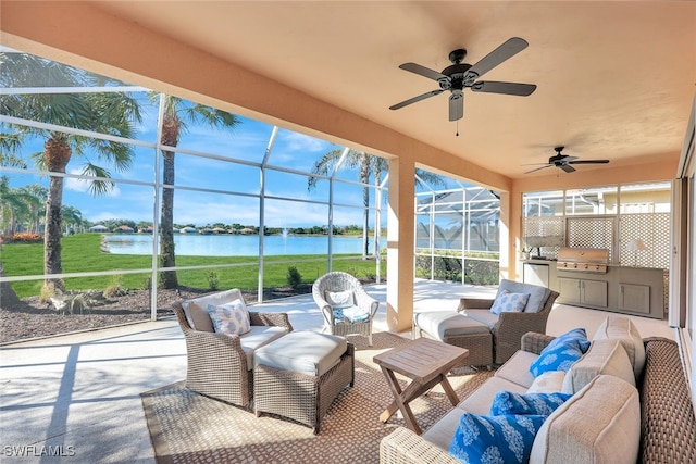 view of patio / terrace featuring grilling area, an outdoor kitchen, a water view, ceiling fan, and a lanai