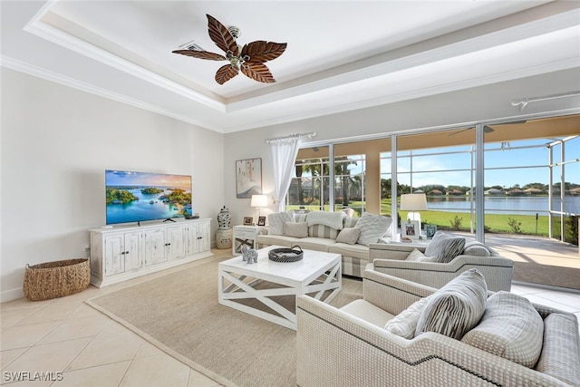 tiled living room featuring a tray ceiling, ceiling fan, and ornamental molding