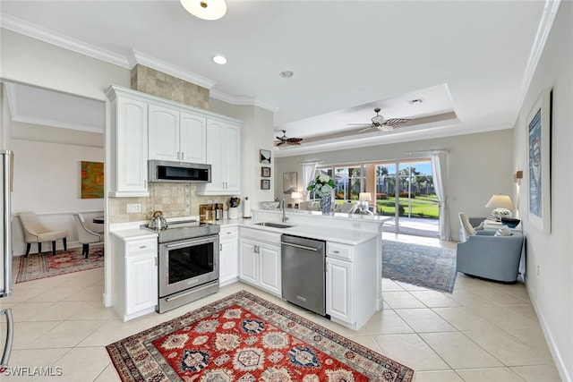 kitchen featuring white cabinetry, sink, kitchen peninsula, decorative backsplash, and appliances with stainless steel finishes