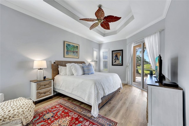 bedroom with access to exterior, light wood-type flooring, ornamental molding, a raised ceiling, and ceiling fan