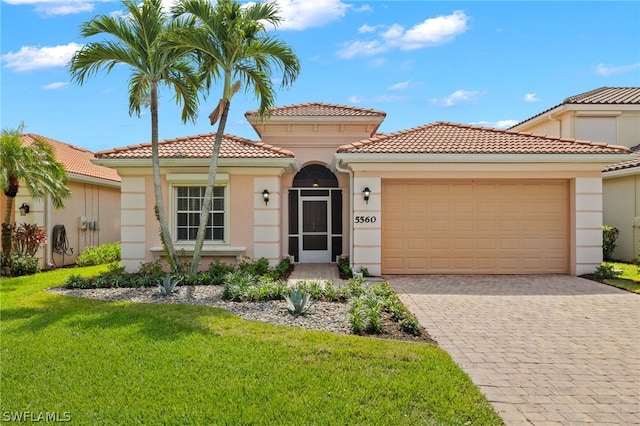 mediterranean / spanish-style home featuring a garage and a front lawn