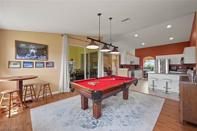 game room featuring billiards, light hardwood / wood-style flooring, and vaulted ceiling