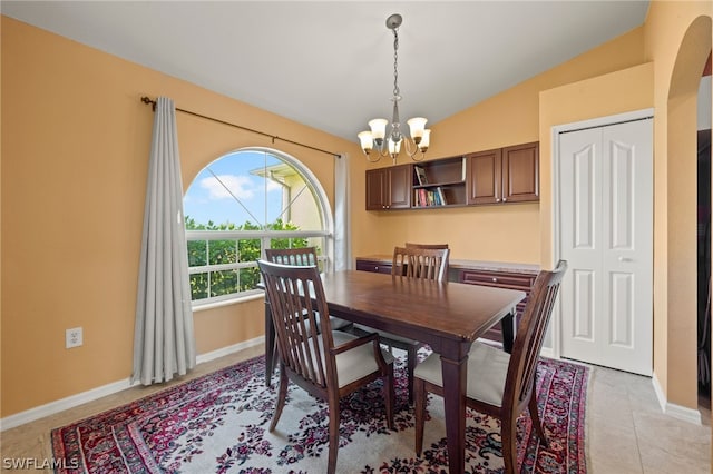 dining area with light tile patterned flooring, a chandelier, and vaulted ceiling