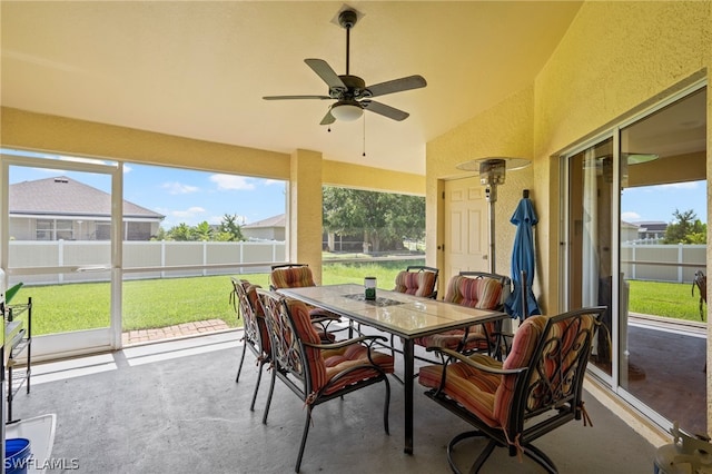 sunroom / solarium featuring ceiling fan, a wealth of natural light, and vaulted ceiling