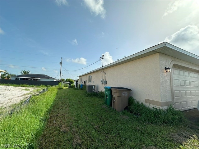 exterior space featuring central AC unit and a garage