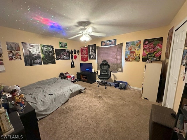 bedroom with carpet flooring, a textured ceiling, a closet, and ceiling fan