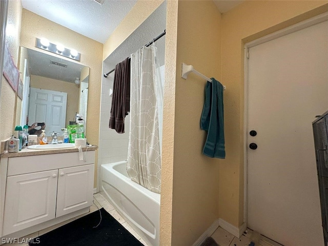 bathroom with vanity, tile patterned floors, a textured ceiling, and shower / tub combo