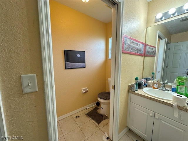 bathroom with vanity, toilet, and tile patterned floors