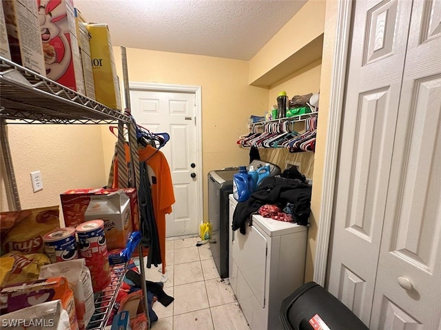 laundry area featuring a textured ceiling, independent washer and dryer, and light tile patterned floors