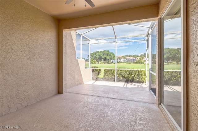 unfurnished sunroom featuring ceiling fan