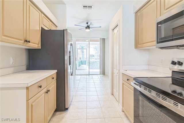 kitchen featuring appliances with stainless steel finishes, light tile patterned floors, and ceiling fan